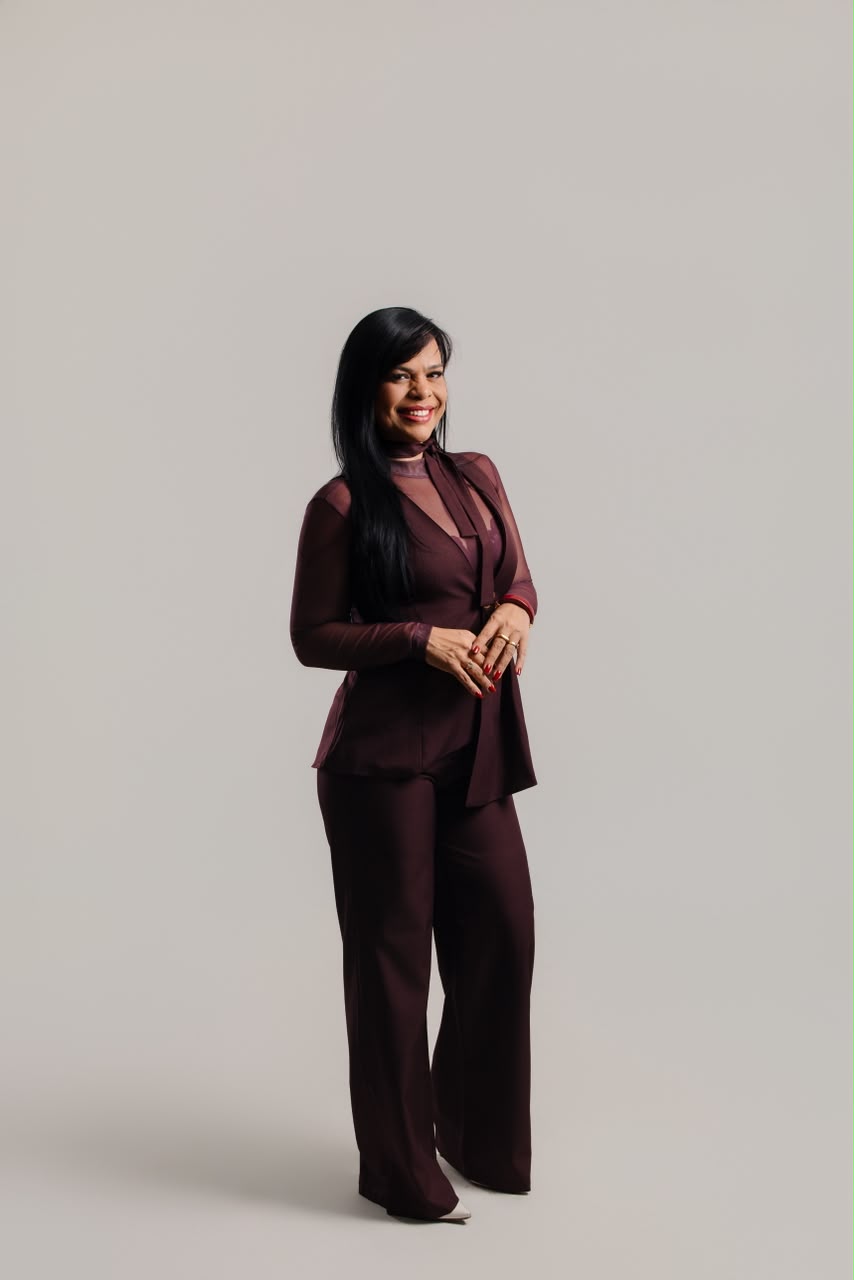 Dra. Marselle Monda sentada, em traje branco, em ensaio editorial